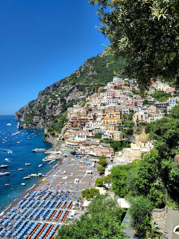 A beautiful panoramic view of Positano with colorful houses cascading down the cliffside to the blue sea.