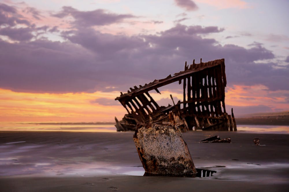 The iconic Peter Iredale shipwreck against a vibrant sunset on the Oregon coast | Famous Shipwreck Locations