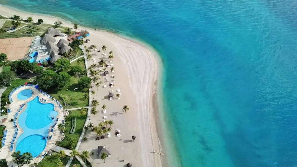 Breathtaking aerial view of a luxurious beach resort in Haiti with turquoise waters and a stunning pool area.
