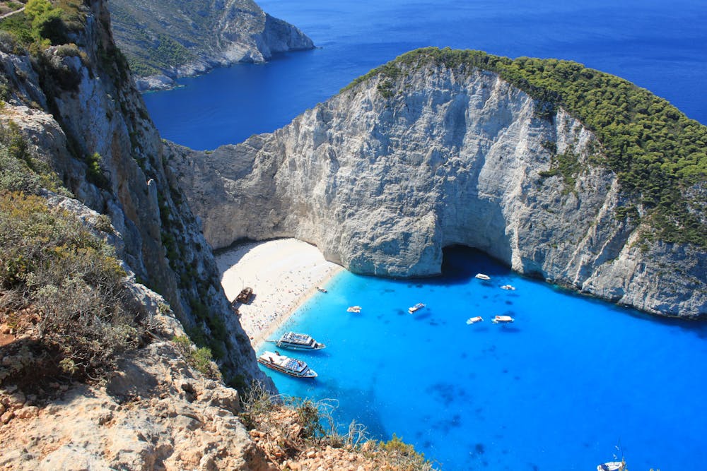Breathtaking aerial view of the turquoise waters and cliffs at Navagio Beach, Zakinthos, Greece.