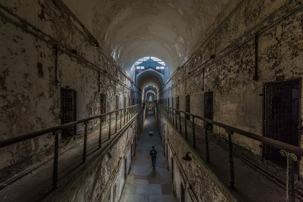 man walking near cubicles inside Eastern State Penitentiary