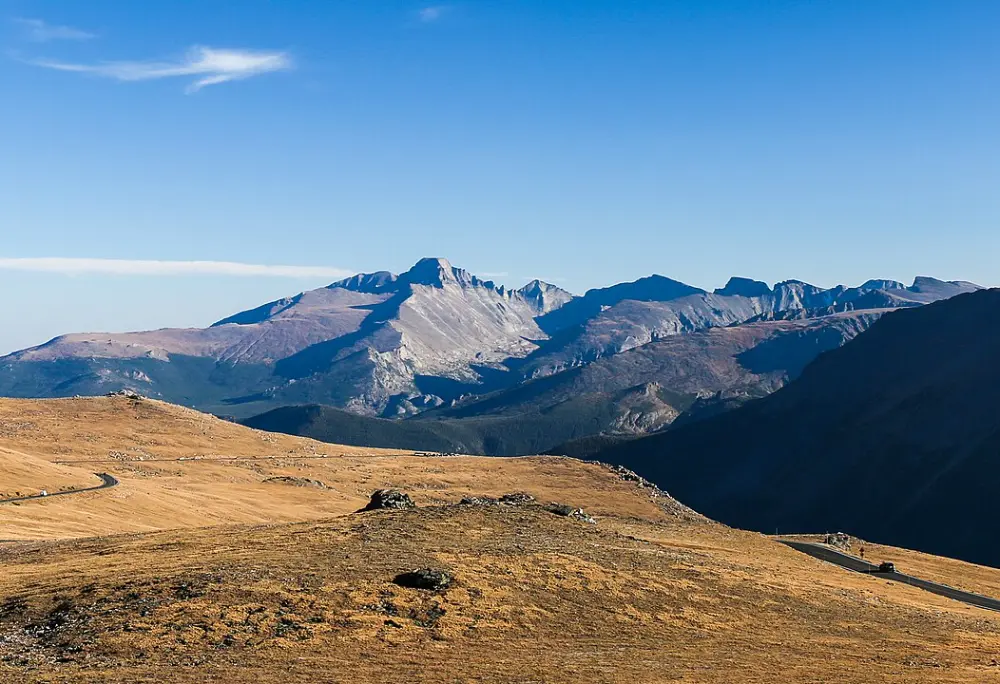 Trail Ridge Road, with Longs Peak (left of center), Pagoda Mountain (center, in sun), Chiefs Head Peak (right of center, in shadow), and Terra Tomah Mountain (at far right edge, in shadow), from 12,000 feet (3,700 m) above sea level in Rocky Mountain National Park