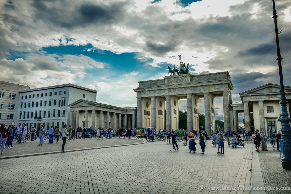 a large group of people walking around a large building with Brandenburg Gate in the background